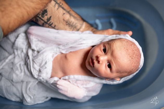 Bain de bébé, bain enveloppé, séance photo naissance à domicile, reportage lifestyle, Thann, Haut-Rhin